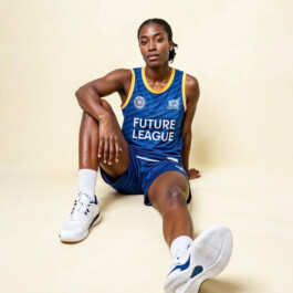 Basketball player in the blue DBV Charlottenburg kit sitting on a cream backdrop 