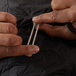 Hands adjusting the elastic drawcord of the runamics OrganicShade windbreaker 