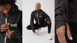 Windbreaker details: zip closure, woman crouching in the jacket and sleeve cuff 
